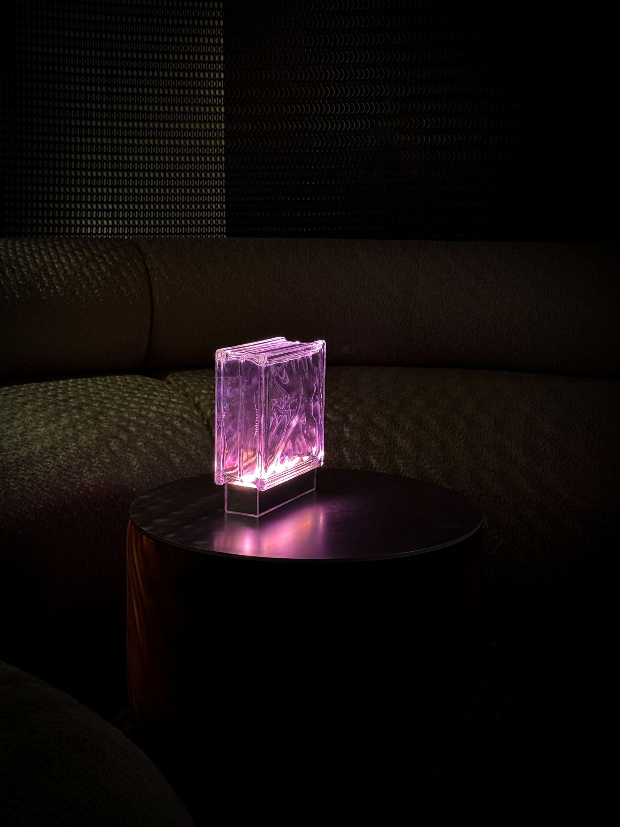 Pink transparent block light on a dark surface with a dark background